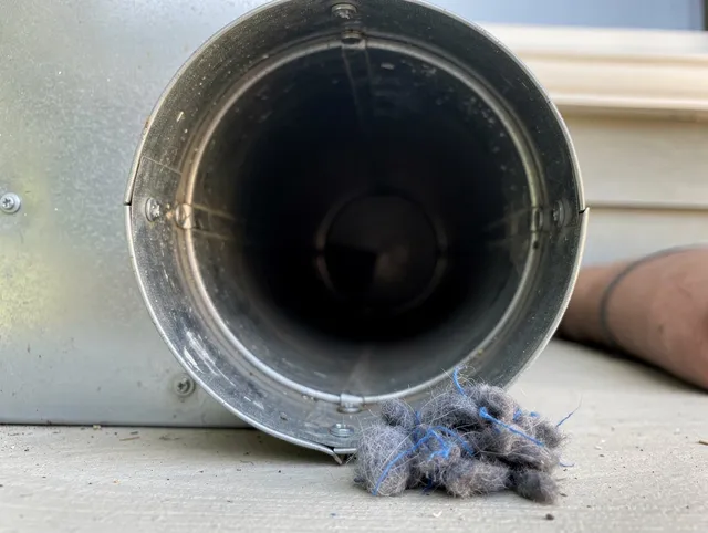 Norton Dryer Vent Cleaning technician using specialized equipment to clear severe dryer vent blockage in Norton